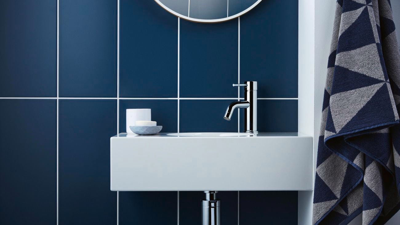 A bathroom sink with a towel hanging on a wall