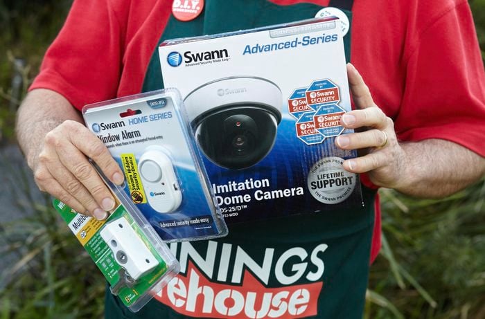 Person holding home security camera devices.
