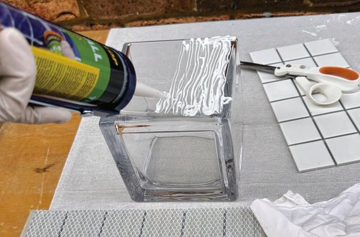 Applying glue to a cube shaped glass vase