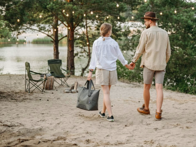 a lady and man holding hands and strolling towards their camp chairs