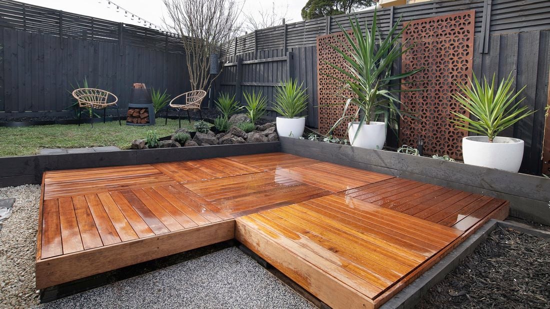 A raised deck in a backyard made up of eight sections of modular decking