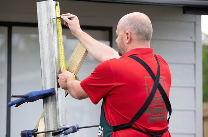 A post being measured and marked by a Bunnings team member