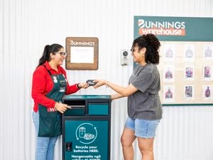 Person handing another person a power tool battery.