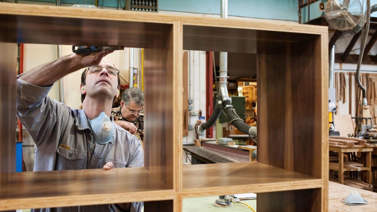 A man fixing a timber cube shelving unit