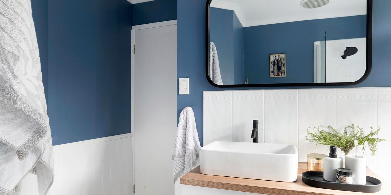 Updated bathroom with new vanity, stylish vanity and a black framed mirror.