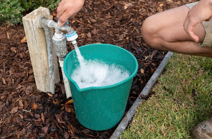 Check water pressure by filling a bucket with water from a garden tap