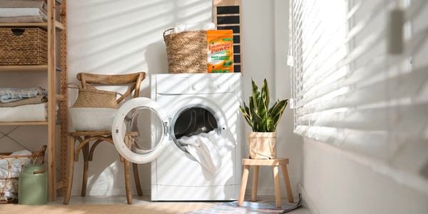 Washing machine with Orange Power cleaner on top.