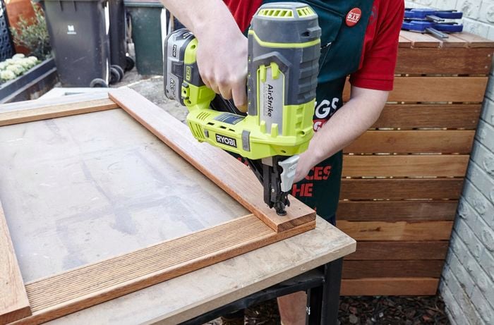 Person using a fixing gun on timber.