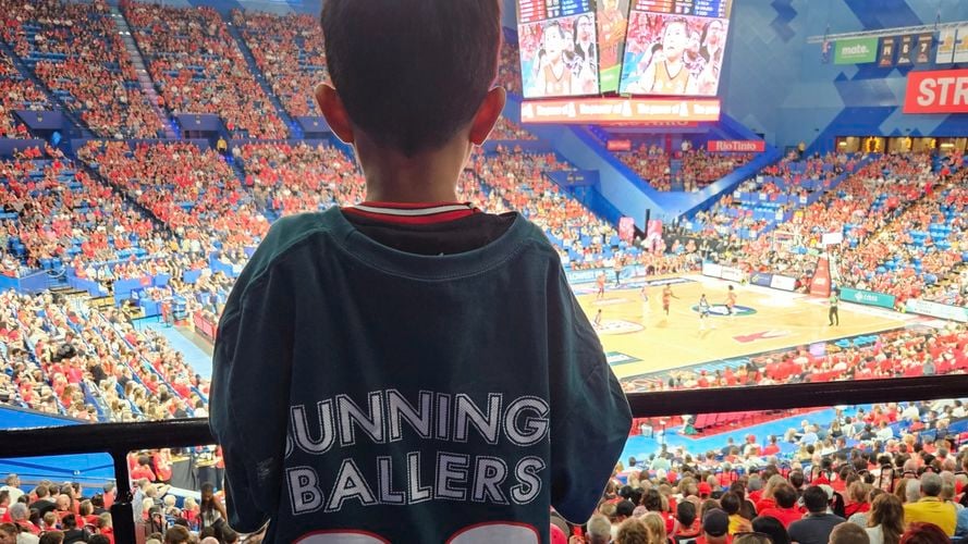 Back of boy wearing a backing ballers tshirt watching basketball game