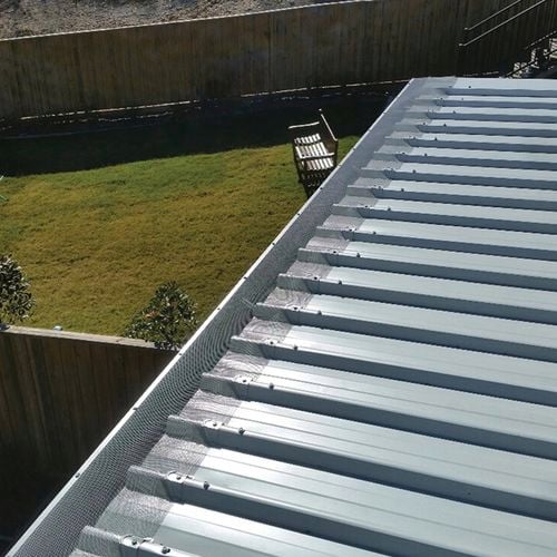 Close up of a roof image with an installed gutter mesh.