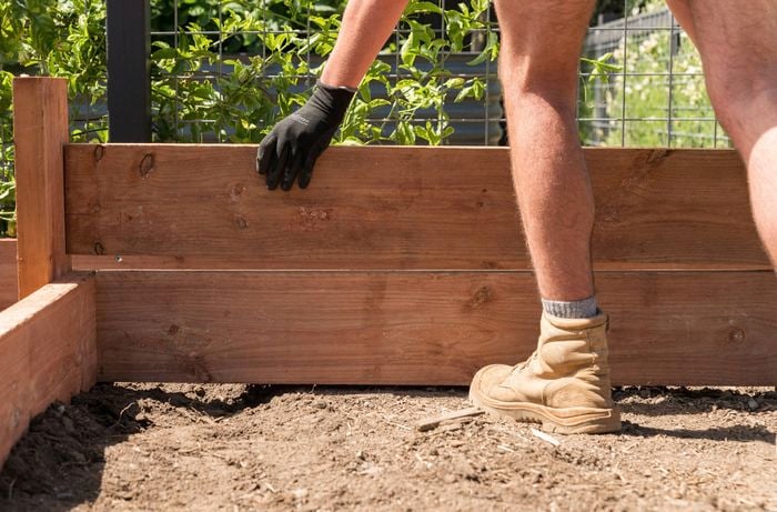 Add additional layers of sleepers on top of the first to build a raised garden bed 