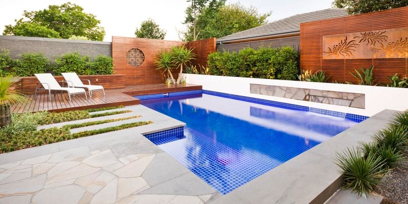 Pool with decking, timber decorative screening and concrete edging