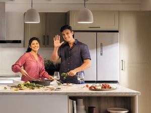Man and woman standing in the kitchen preparing dinner