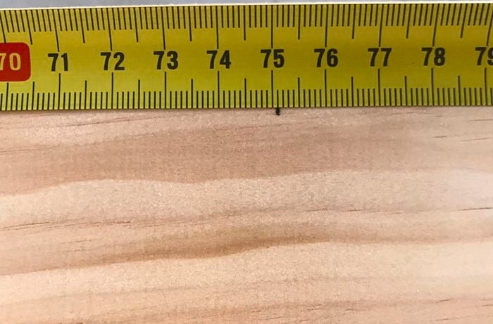 Close-up of a measuring tape and pine timber with a mark at 751 millimetres