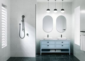 A bathroom with 2 mirrors on the wall, 2 basins on a cupboard and a shower