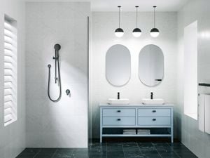 A bathroom with 2 mirrors on the wall, 2 basins on a cupboard and a shower