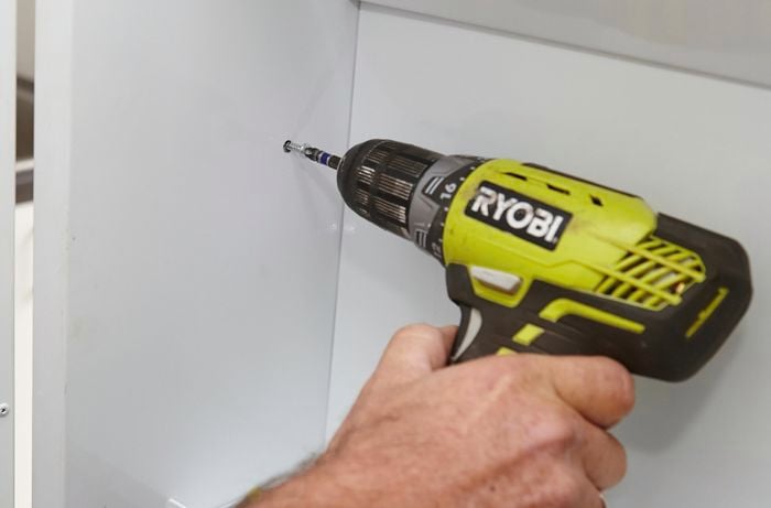 Securing the side panels with a Ryobi drill.