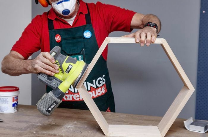 A hexagon shelf being sanded down