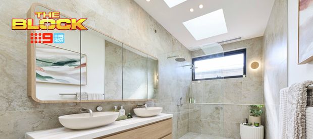 Modern bathroom with a floating timber double vanity, white vessel basins, large mirror, stone-look tiles and a spacious walk-in shower. “The Block” logo appears in the upper-left corner.