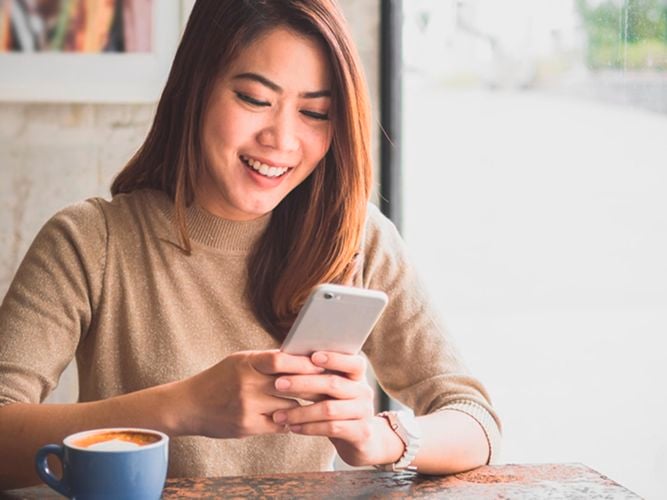Lady with a mobile phone and a cup of coffee