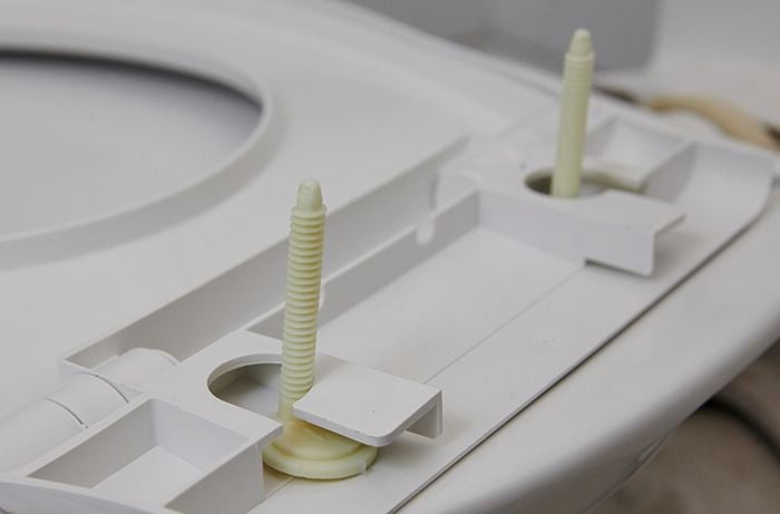 Plastic bolts fitted to the underside of your toilet seat