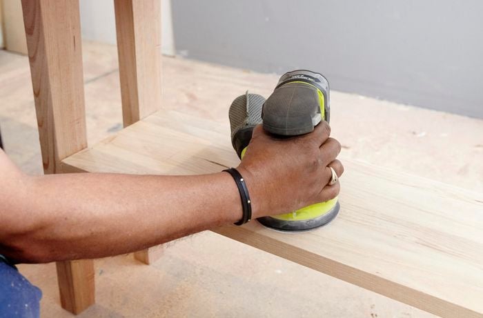 Person sanding table using sander