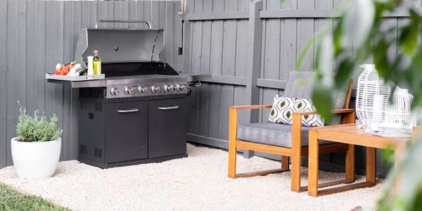 BBQ and outdoor couches on stone area.
