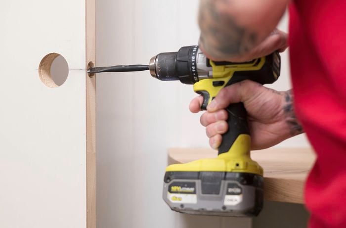 Drill a hole on the edge of the door for the latch