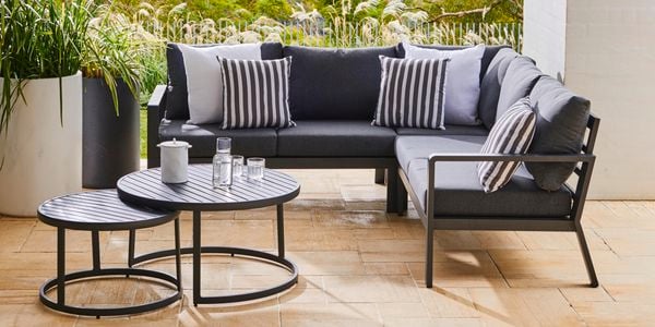 Couch, plants and a coffee table in an outdoor area
