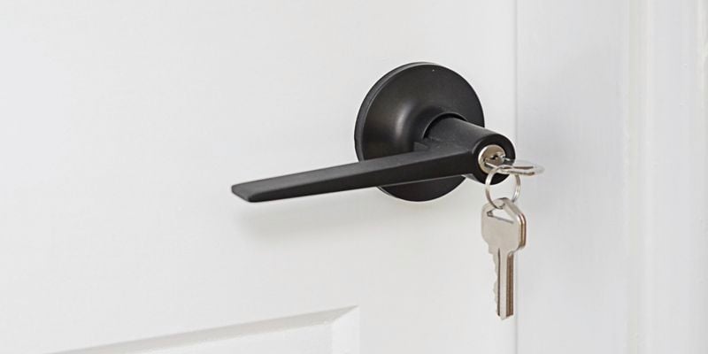 Door handle with a key hanging from it's lock 