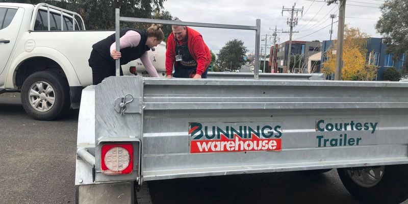 Bunnings team member helping a customer load onto a trailer.