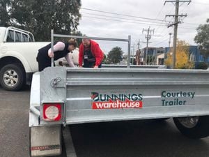 Bunnings team member helping a customer load onto a trailer.
