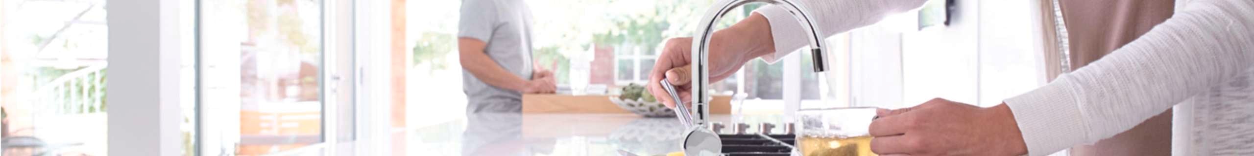 Person filling up cup from tap.
