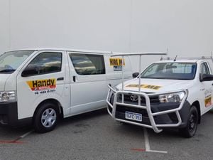 A rental van parked next to a ute. The vehicles are branded for Handy Rentals.