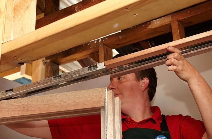 A person assembling a sliding door frame