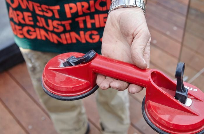 A Bunnings team member holding a glass suction cup handle