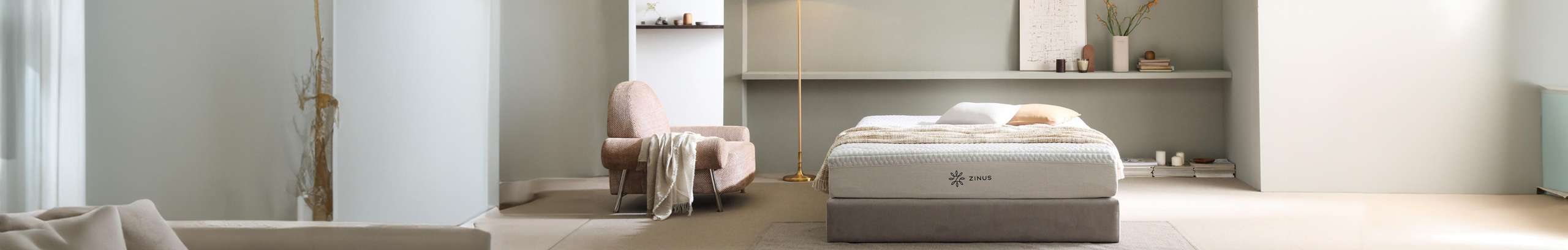 Zinus mattress in bedroom with throw and pillows on top