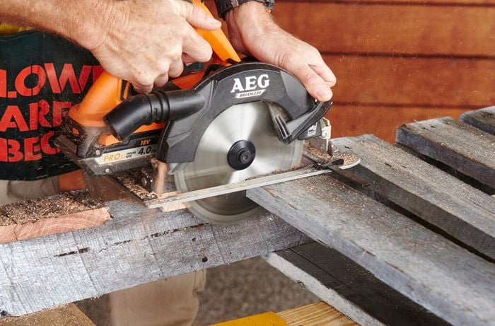 A circular saw being used to cut planks free from an old pallet