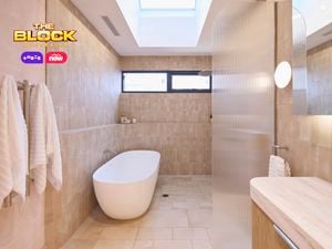 Natural coloured bathroom with a timber fluted profile vanity and marble benchtop and bath.