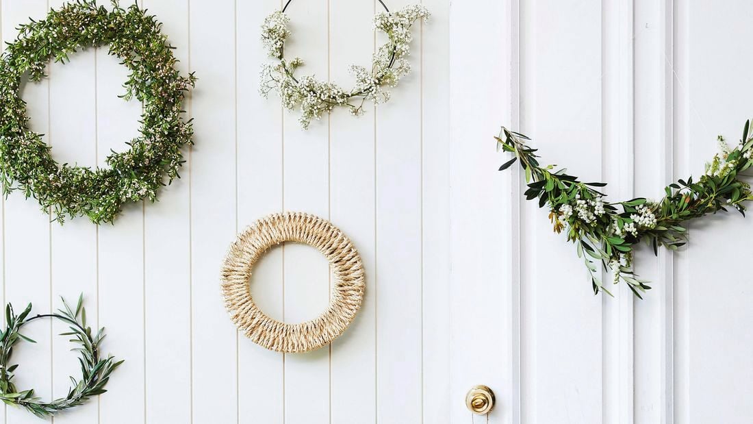Wall filled with Christmas wreaths.