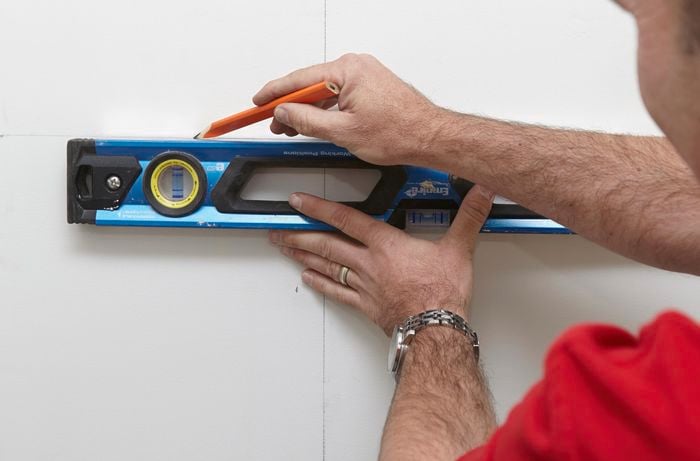 A spirit level used to mark a straight line on the inside of a cabinet