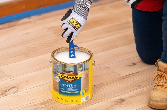 A person is preparing a floor sealer before application, ensuring the floor is protected and ready for everyday use.