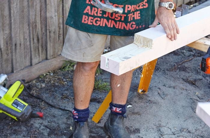 Bunnings team member standing alongside a horizontal wooden post with an indented end cut from it