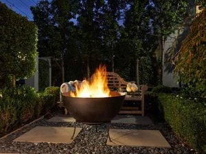 Large gas patio heater with flickering flames in an outdoor living setting.
