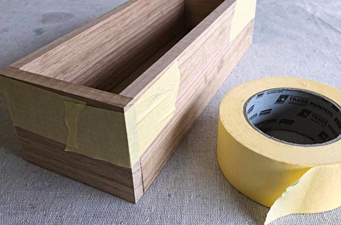 Timber planter box with tape on the sides.
