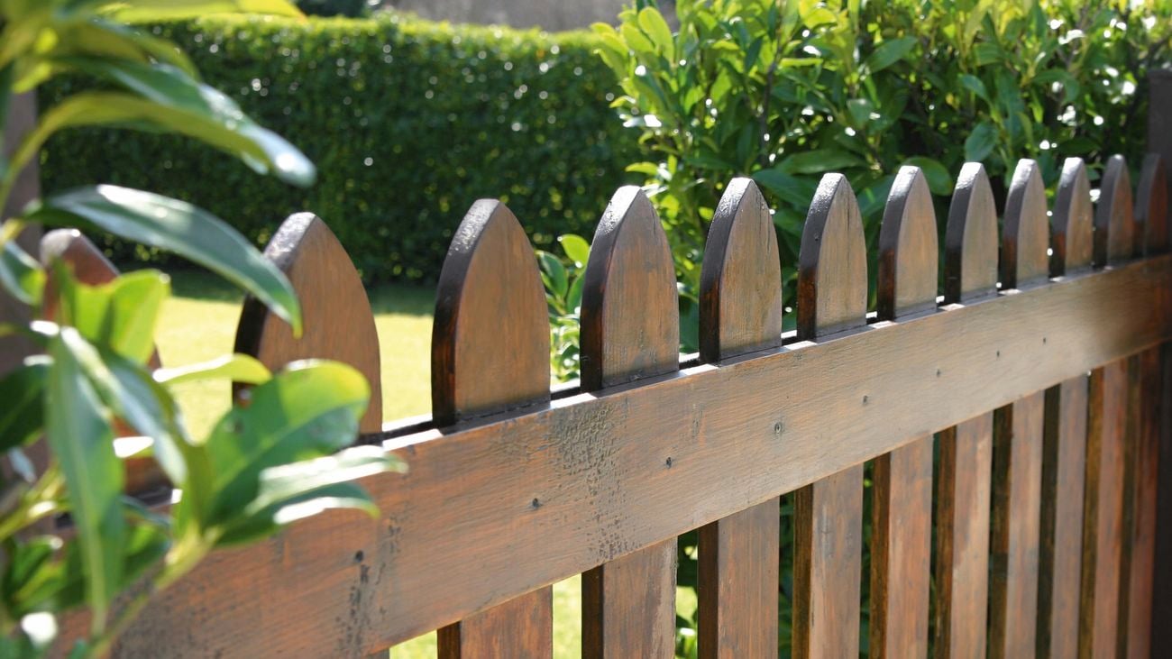 Close up of a Colorbond steel fence in a dark wood stain.