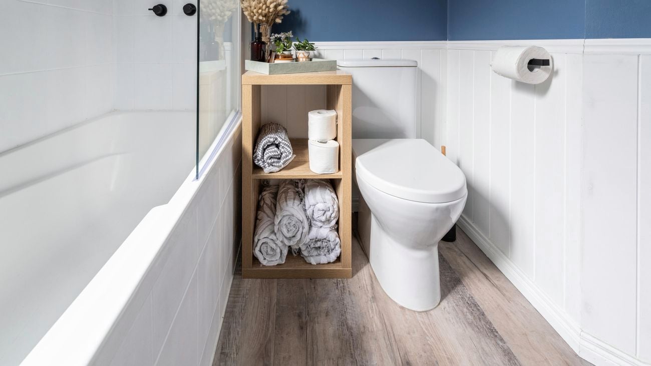 Cube storage unit with towels in a bathroom.