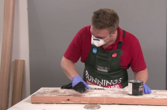 A Bunnings team member waxing a piece of timber