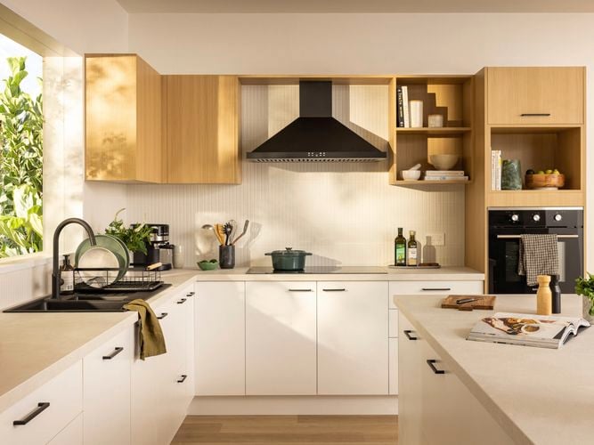 Wide shot of a two-toned kitchen with timber look wall cabinets and white base cabinets.