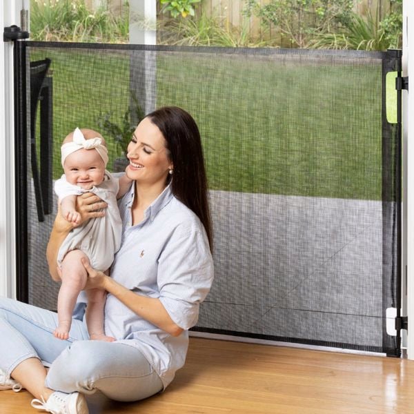 Lady sitting with baby in front of baby gate